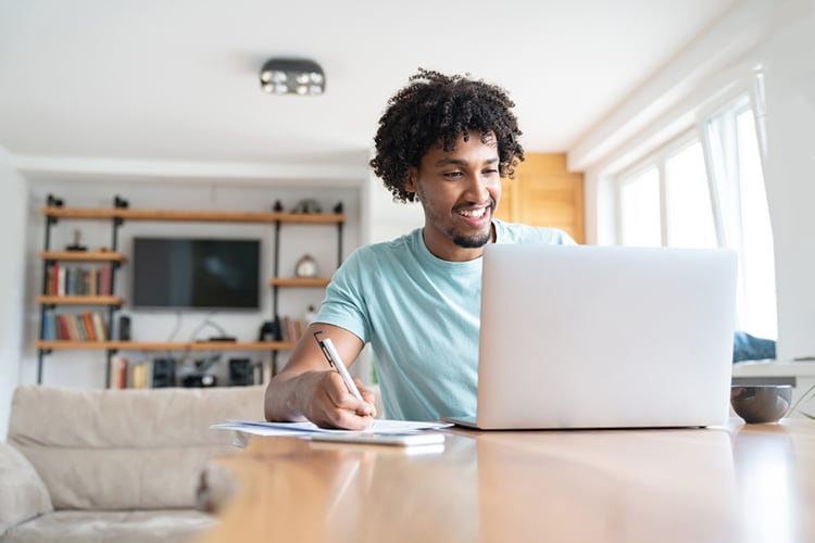 Man sitting at table and using laptop to go over budget